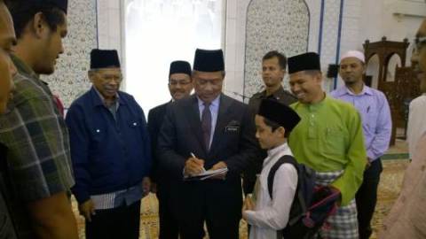 Tan Sri Muhyiddin Yassin signing Ali's autograph at theSeminar Pencerahan Tasawwur Ahli As-Sunnah Wa Al-Jama`ah.